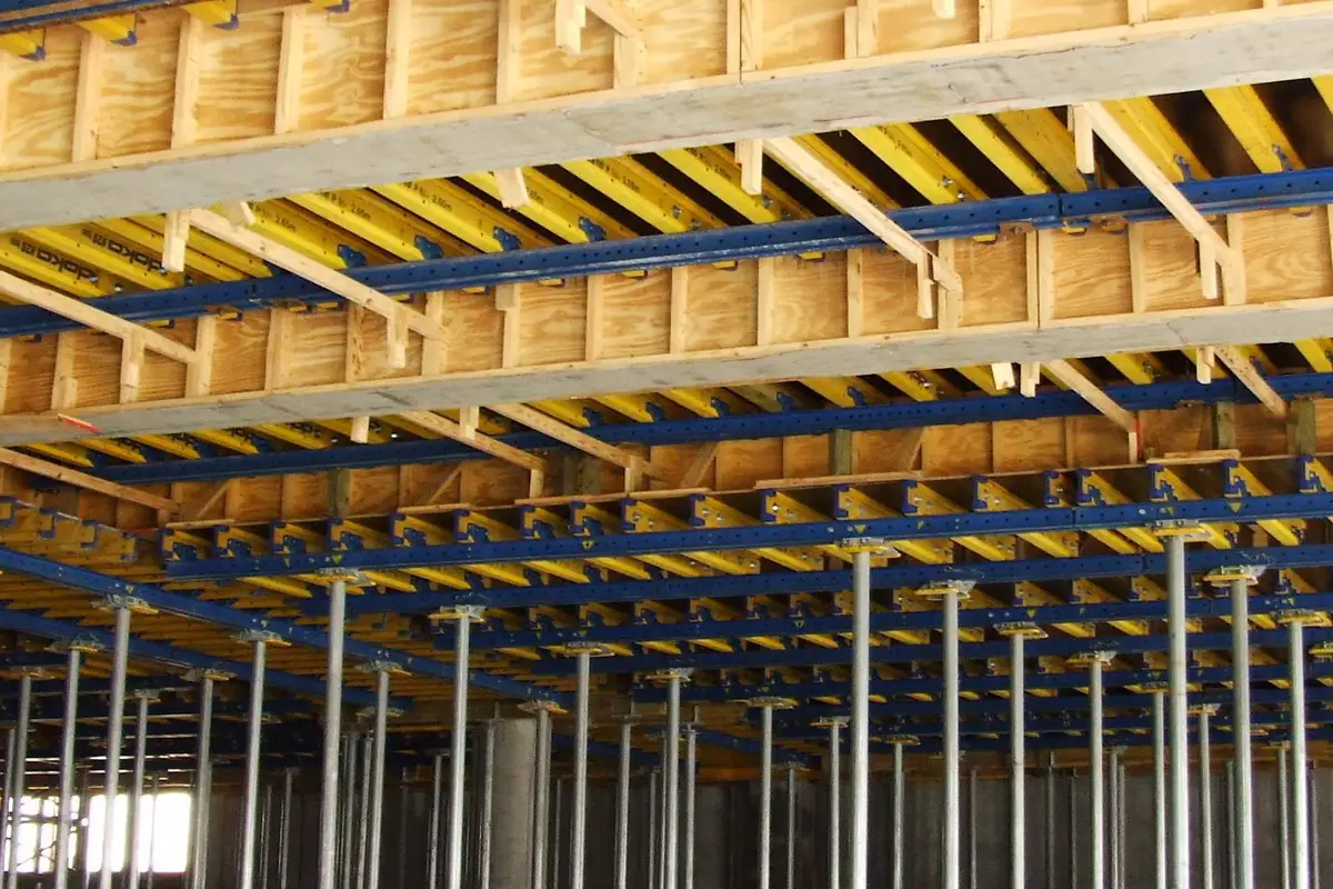 Slab formwork deck with timber beams and steel props supporting a concrete floor