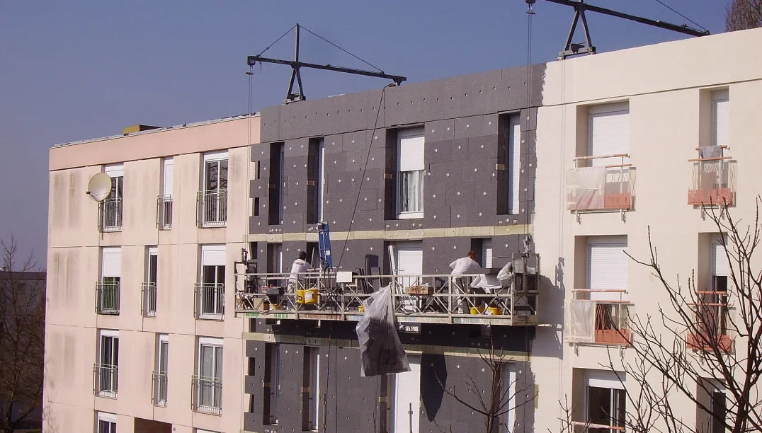 Rigid insulation boards being fixed to a building facade